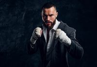 angry-bearded-businessman-suit-protective-kickboxing-gloves-is-posing-photographer-dark-photo-studio