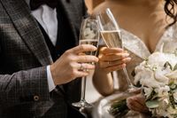 front-view-wedding-couple-s-hands-with-champagne-glasses-wedding-bouquet